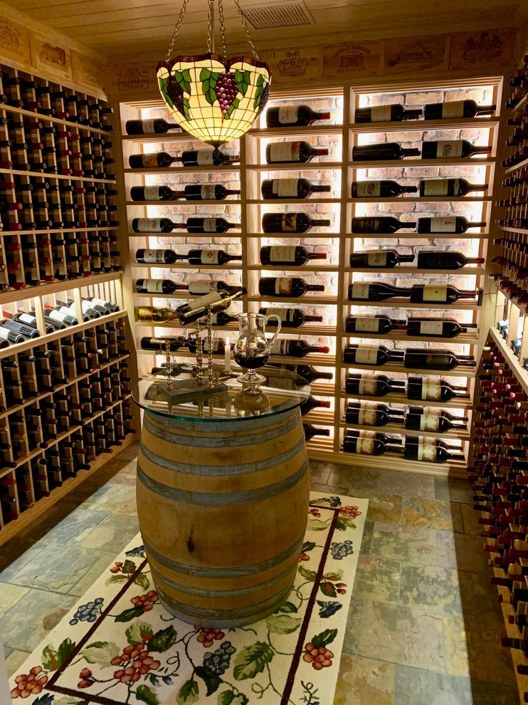 Inspiration for a mid-sized traditional wine cellar in Cincinnati with slate floors, display racks and grey floor.