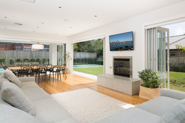 Photo of a contemporary living room in Sydney with white walls, light hardwood floors, a ribbon fireplace and a wall-mounted tv.