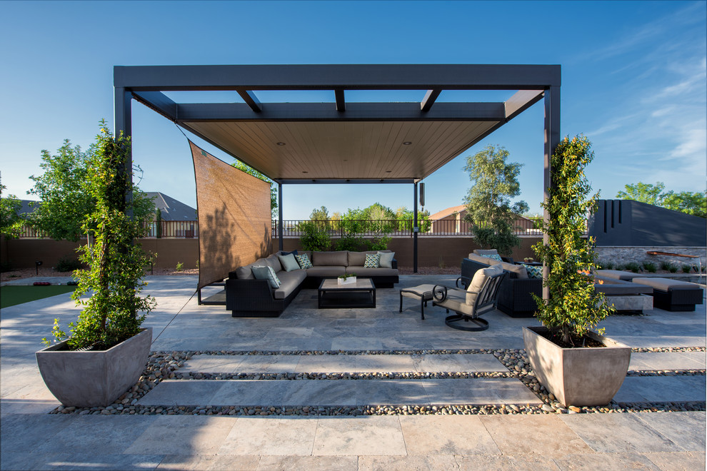 Inspiration for a mid-sized contemporary backyard patio in Phoenix with natural stone pavers and a pergola.