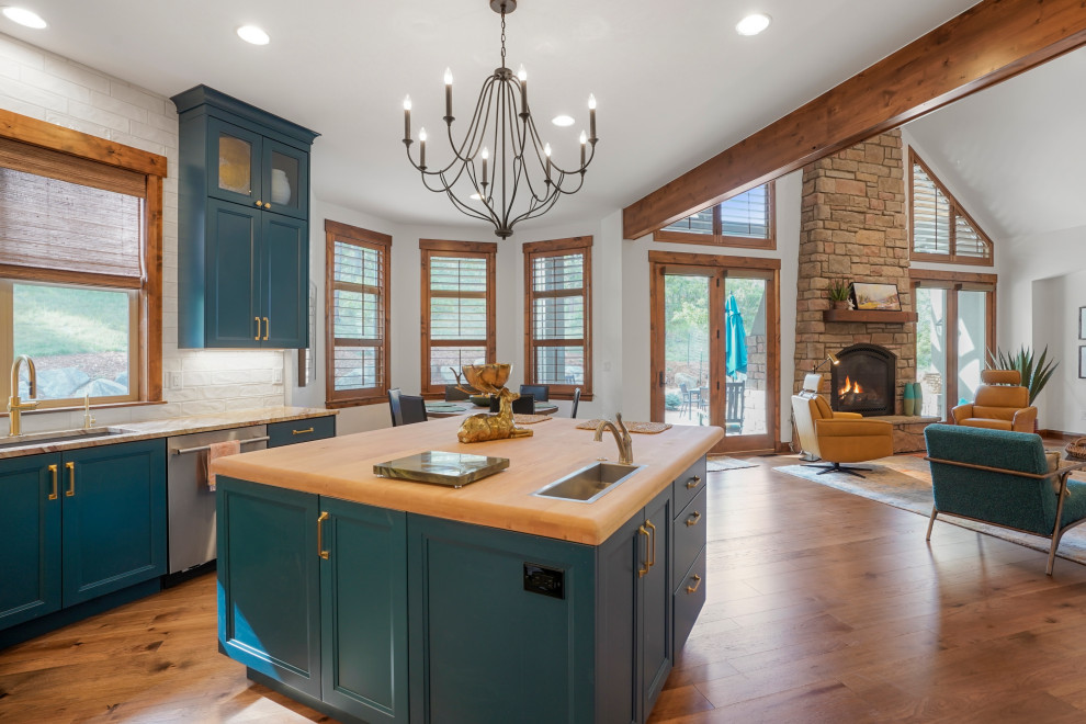 Open concept kitchen - large transitional u-shaped exposed beam open concept kitchen idea in Denver with an undermount sink, recessed-panel cabinets, blue cabinets, wood countertops, white backsplash, stainless steel appliances and an island