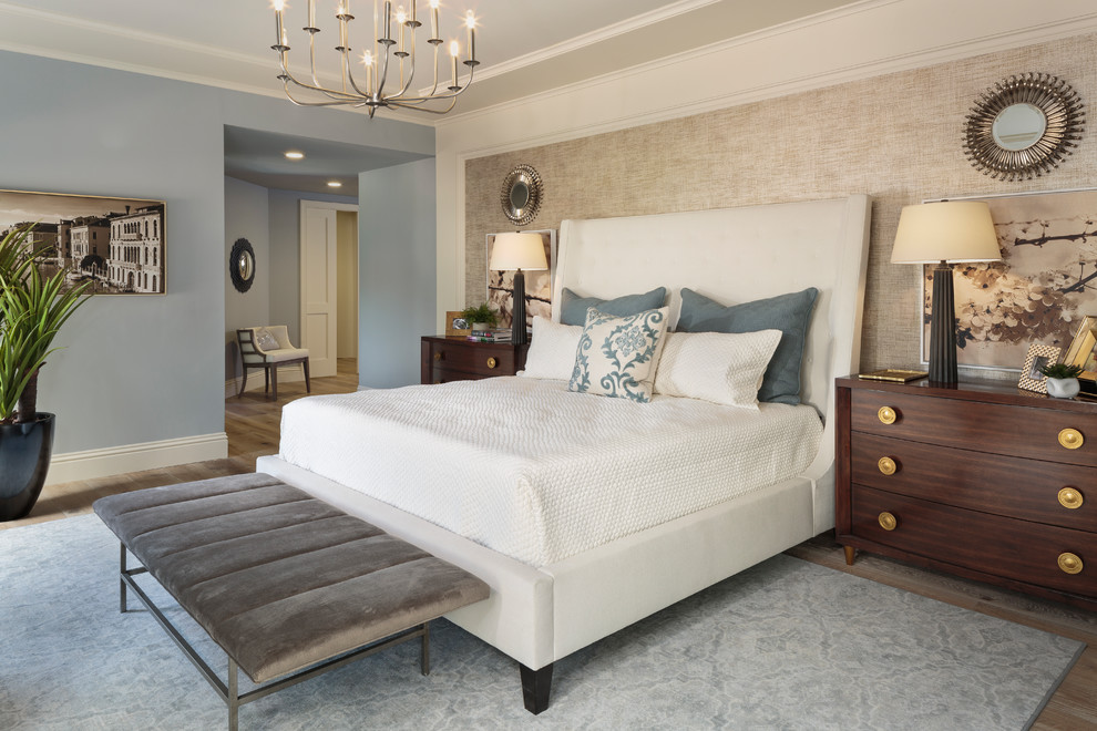 This is an example of a transitional master bedroom in Other with beige walls and light hardwood floors.
