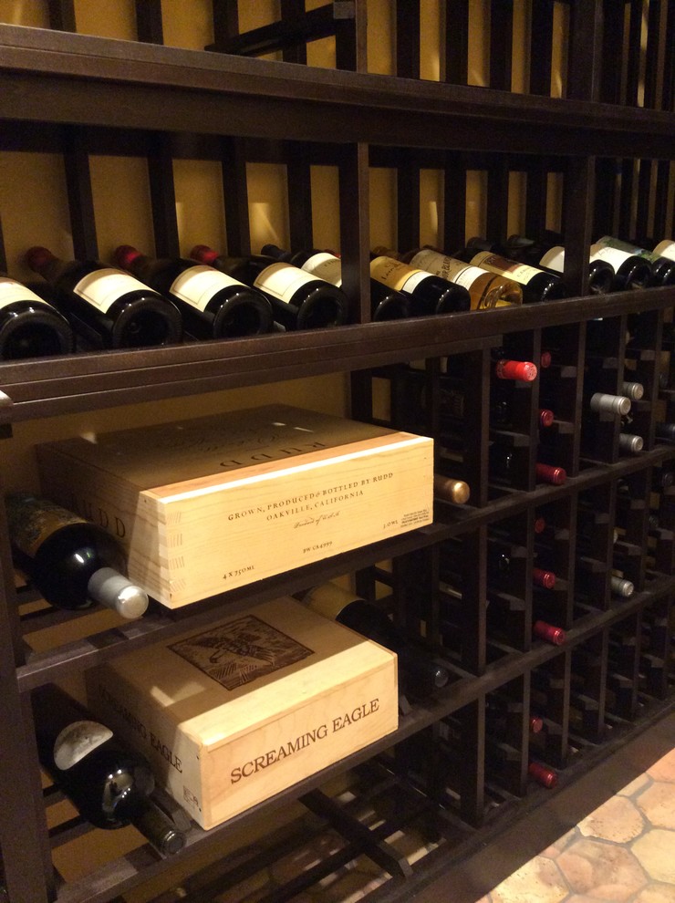 Photo of a mid-sized traditional wine cellar in Los Angeles with terra-cotta floors and display racks.