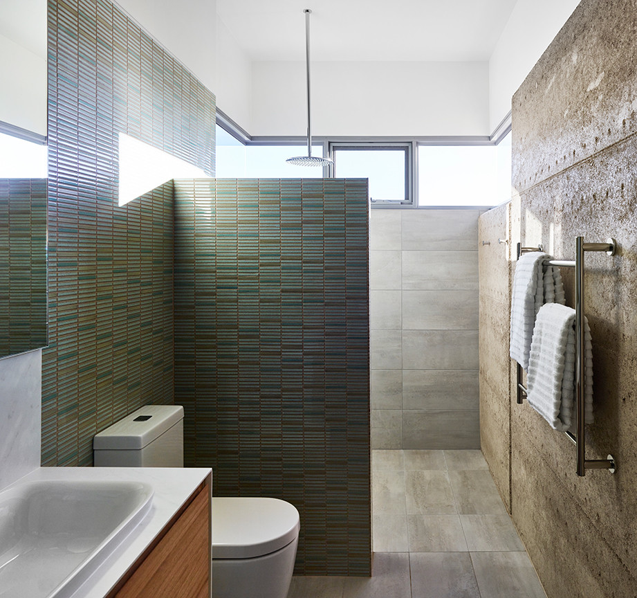 Inspiration for a mid-sized contemporary master bathroom in Brisbane with furniture-like cabinets, brown cabinets, an open shower, a one-piece toilet, blue tile, ceramic tile, porcelain floors, a drop-in sink, tile benchtops, grey floor, an open shower, a niche, a single vanity and a floating vanity.