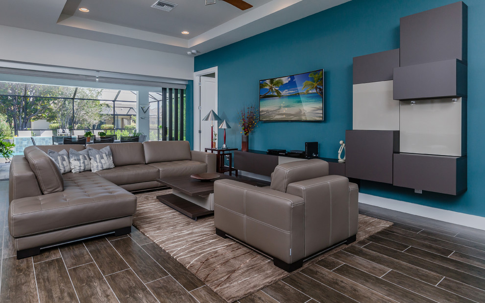 Design ideas for a contemporary living room in Miami with blue walls, a wall-mounted tv and brown floor.