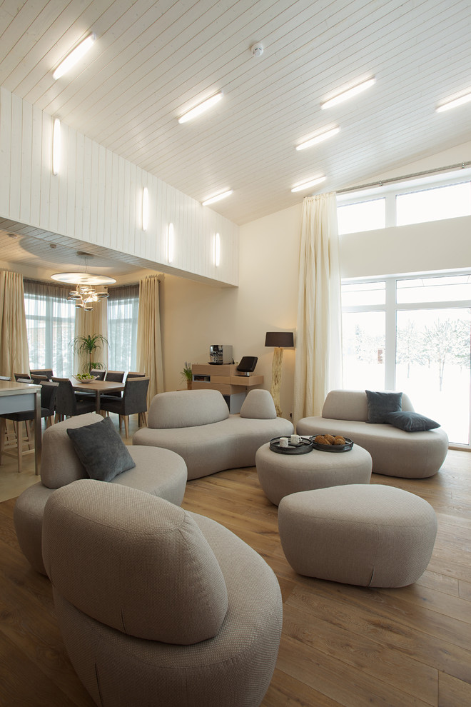 This is an example of a contemporary open concept living room with beige walls and no tv.