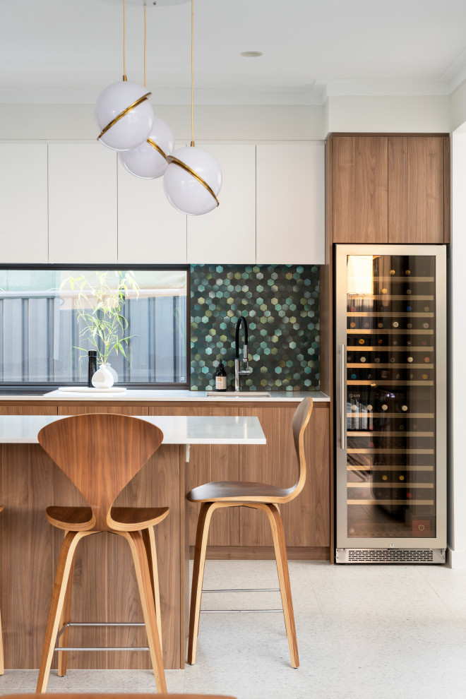 Inspiration for a midcentury galley kitchen in Perth with an undermount sink, flat-panel cabinets, medium wood cabinets, green splashback, mosaic tile splashback, with island, white floor and white benchtop.