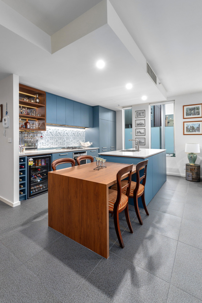 Large modern galley eat-in kitchen in Melbourne with an undermount sink, flat-panel cabinets, blue cabinets, quartz benchtops, blue splashback, porcelain splashback, black appliances, porcelain floors, multiple islands, grey floor and white benchtop.