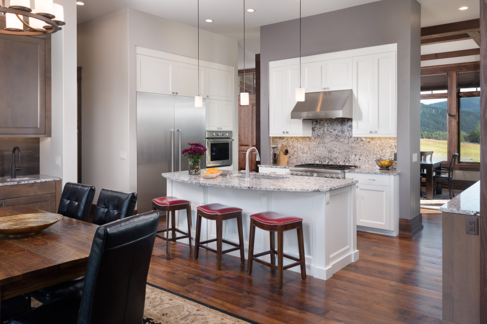 Mountain style u-shaped dark wood floor eat-in kitchen photo with an undermount sink, recessed-panel cabinets, white cabinets, granite countertops, granite backsplash, stainless steel appliances and an island