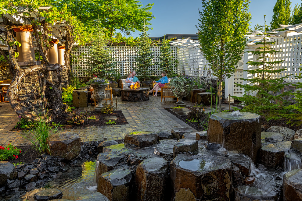 シアトルにある高級な広いヴィクトリアン調のおしゃれな裏庭のテラス (ファイヤーピット、天然石敷き、パーゴラ) の写真