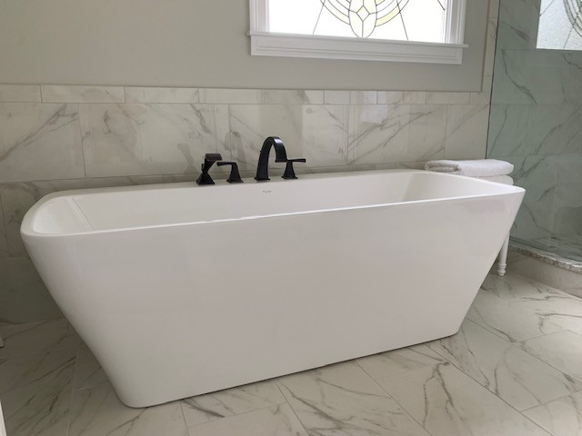 Freestanding bathtub - mid-sized transitional master white tile porcelain tile, white floor and double-sink freestanding bathtub idea with recessed-panel cabinets, white cabinets, a two-piece toilet, gray walls, an undermount sink, granite countertops, a hinged shower door, beige countertops and a built-in vanity
