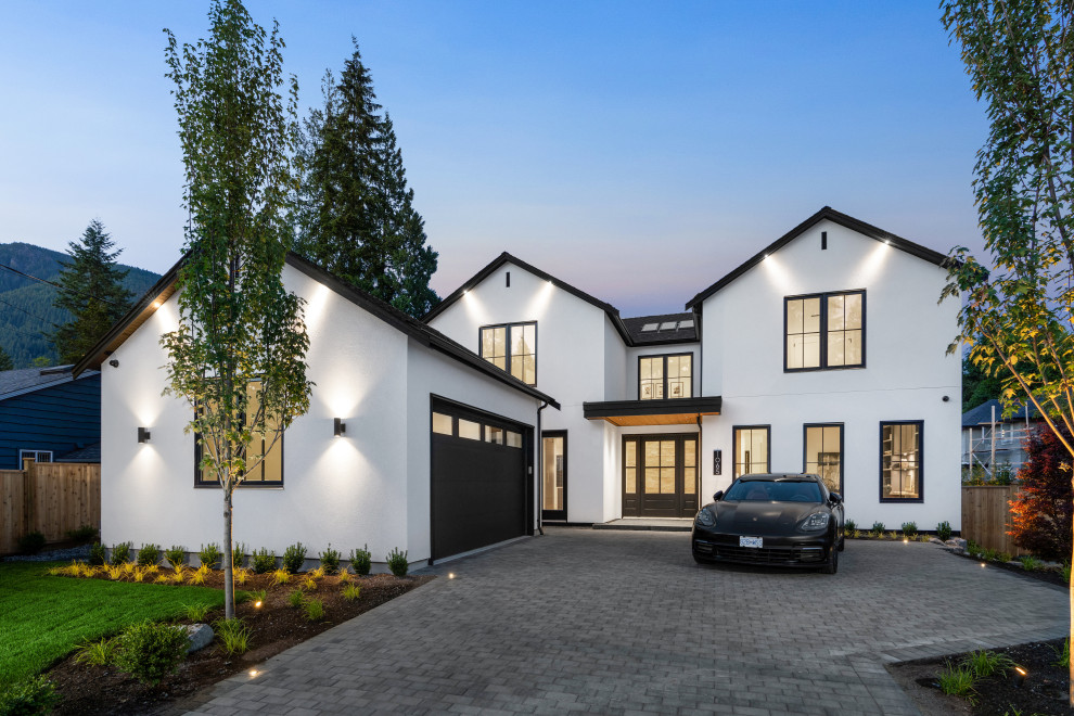Example of a large transitional white two-story stucco exterior home design in Vancouver