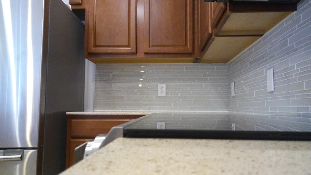 Eat-in kitchen - mid-sized transitional l-shaped eat-in kitchen idea with quartz countertops, white backsplash, glass tile backsplash and a peninsula