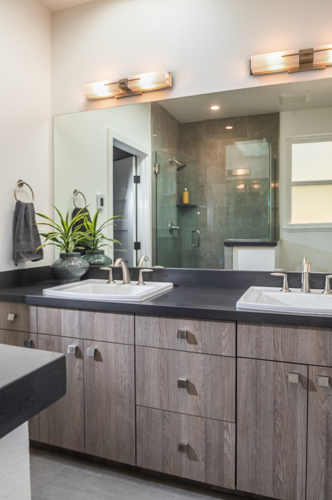 Design ideas for a large contemporary master bathroom in Other with flat-panel cabinets, medium wood cabinets, gray tile, porcelain tile, white walls, porcelain floors, a drop-in sink, engineered quartz benchtops, grey floor, a hinged shower door, black benchtops, a double vanity and a built-in vanity.