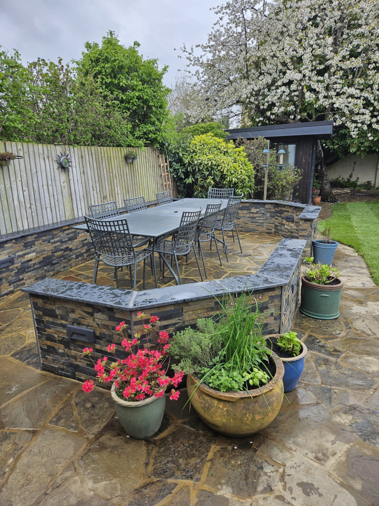 Cette photo montre une terrasse avec des plantes en pots arrière montagne de taille moyenne avec des pavés en pierre naturelle et aucune couverture.