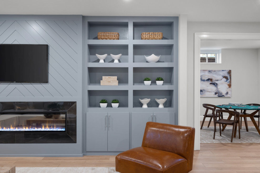 Basement - huge transitional look-out laminate floor and brown floor basement idea in Boston with gray walls, a standard fireplace and a tile fireplace