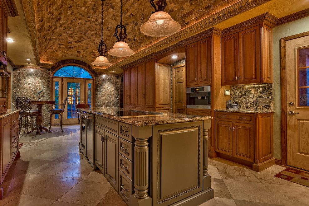 Photo of an expansive mediterranean u-shaped eat-in kitchen in Omaha with a drop-in sink, raised-panel cabinets, medium wood cabinets, granite benchtops, stainless steel appliances, travertine floors and with island.