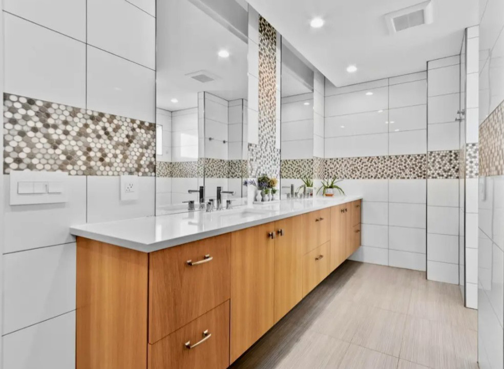 Example of a large transitional master porcelain tile doorless shower design with a hinged shower door and a floating vanity