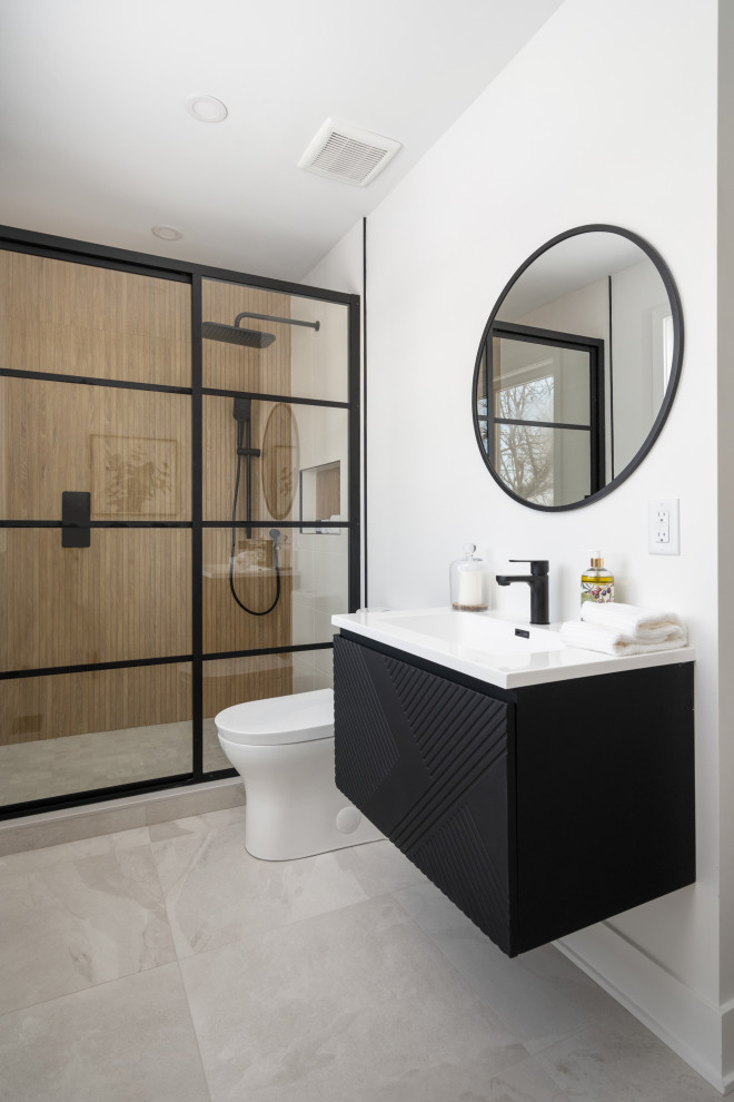 Design ideas for a mid-sized modern master bathroom in Montreal with furniture-like cabinets, black cabinets, an alcove shower, a one-piece toilet, brown tile, white walls, ceramic floors, an integrated sink, engineered quartz benchtops, grey floor, a sliding shower screen, white benchtops, a single vanity, a floating vanity and wood-look tile.