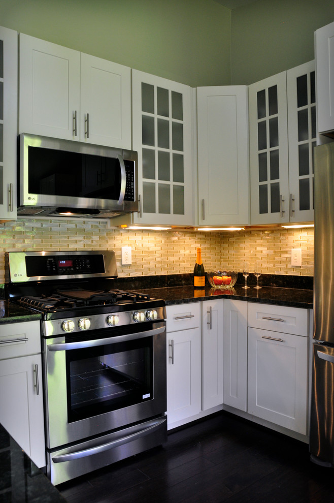 Example of a mid-sized transitional u-shaped dark wood floor eat-in kitchen design in DC Metro with an undermount sink, shaker cabinets, white cabinets, granite countertops, yellow backsplash, glass tile backsplash, stainless steel appliances and a peninsula
