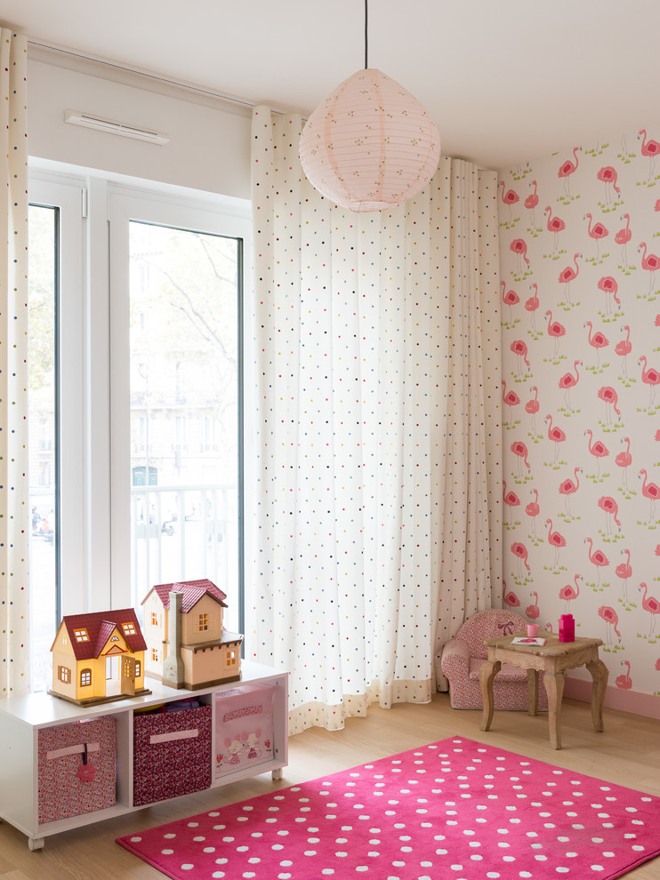 Design ideas for a mid-sized scandinavian kids' bedroom for kids 4-10 years old and girls in Paris with pink walls, beige floor and light hardwood floors.