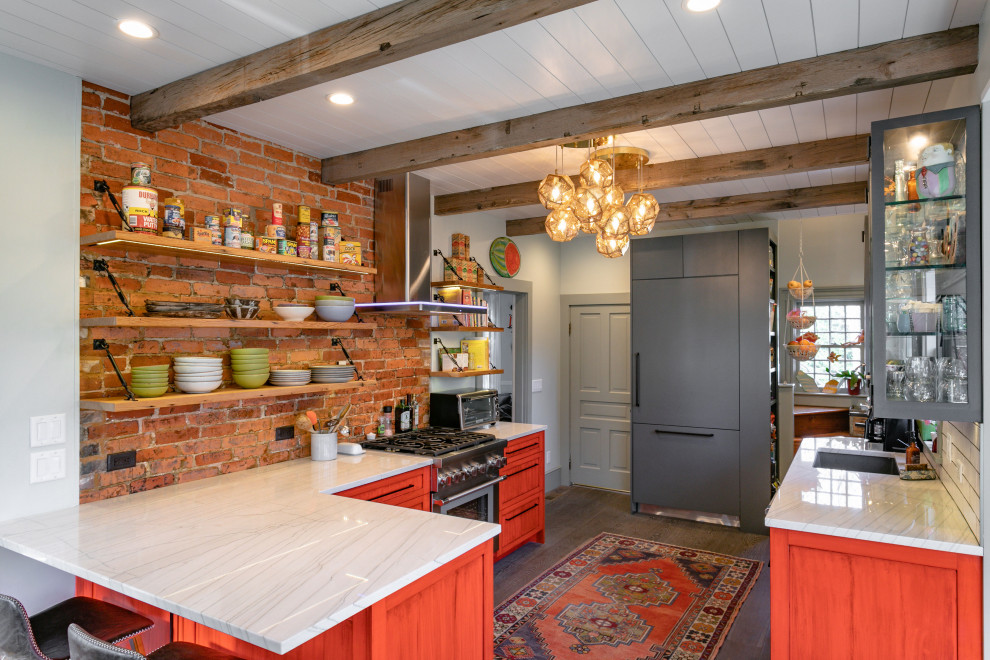 Design ideas for a country l-shaped kitchen in Other with an undermount sink, shaker cabinets, orange cabinets, red splashback, brick splashback, panelled appliances, dark hardwood floors, a peninsula, brown floor, white benchtop, exposed beam and timber.