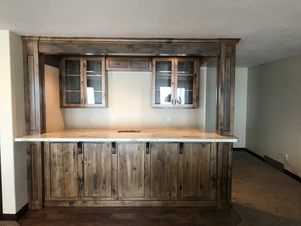 Mid-sized country galley wet bar in Other with a drop-in sink, recessed-panel cabinets, dark wood cabinets, granite benchtops, dark hardwood floors and brown floor.