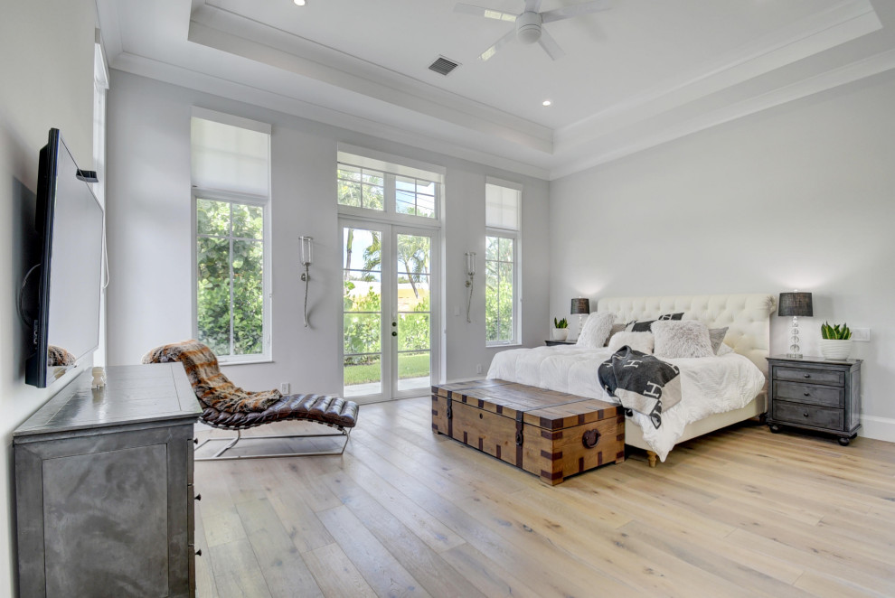 Inspiration for a large beach style master bedroom in Other with white walls, light hardwood floors and brown floor.