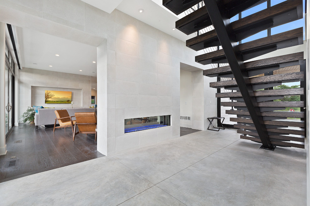 Photo of a mid-sized contemporary foyer in Minneapolis with white walls, concrete floors, a double front door, a glass front door and grey floor.