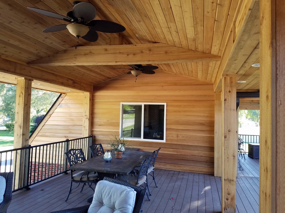 Inspiration for a large backyard deck remodel with a roof extension