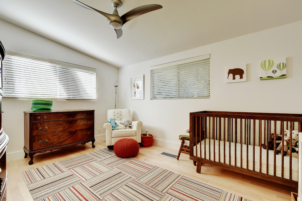 Inspiration for a large midcentury gender-neutral nursery in Austin with white walls, light hardwood floors and beige floor.