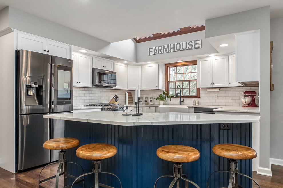 Large transitional u-shaped eat-in kitchen photo in Columbus with shaker cabinets, quartz countertops, white backsplash and an island