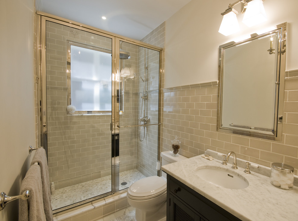 Traditional bathroom in New York with marble benchtops and subway tile.