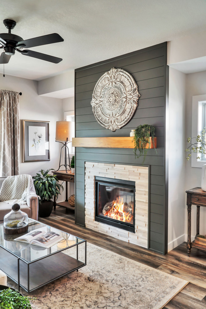 This is an example of a mid-sized country open concept living room in Other with white walls, vinyl floors, a standard fireplace, a tile fireplace surround, multi-coloured floor and planked wall panelling.