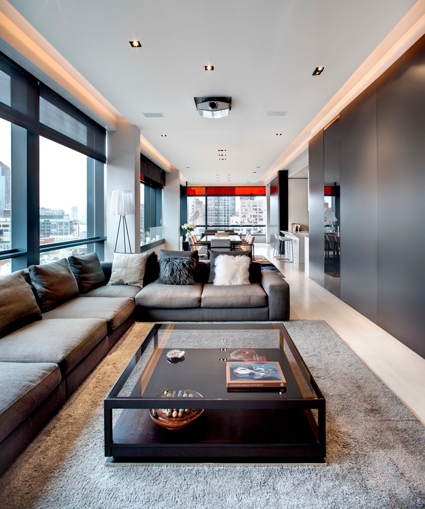 Mid-sized trendy open concept light wood floor and beige floor living room photo in New York with gray walls and a concealed tv
