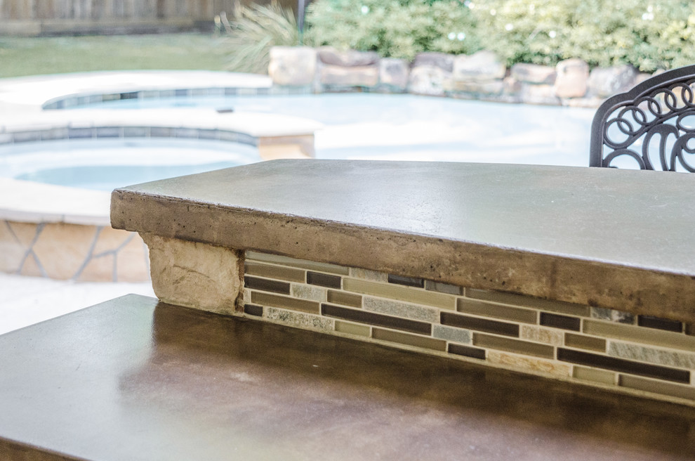 Inspiration for a traditional backyard patio in Dallas with an outdoor kitchen, concrete slab and a roof extension.
