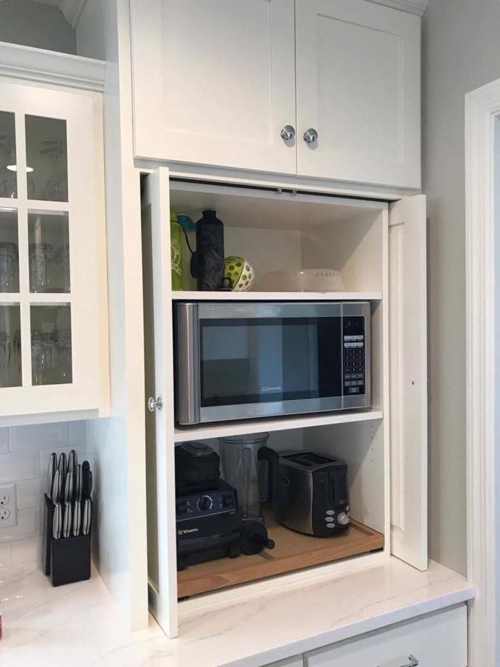 Kitchen - transitional l-shaped kitchen idea in Philadelphia with a farmhouse sink, shaker cabinets, white cabinets, marble countertops, white backsplash, subway tile backsplash, stainless steel appliances and an island