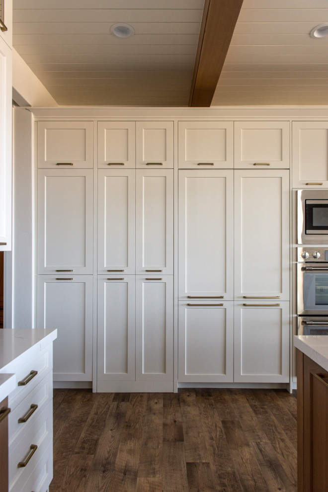 Photo of a large country eat-in kitchen in Salt Lake City with white cabinets and with island.