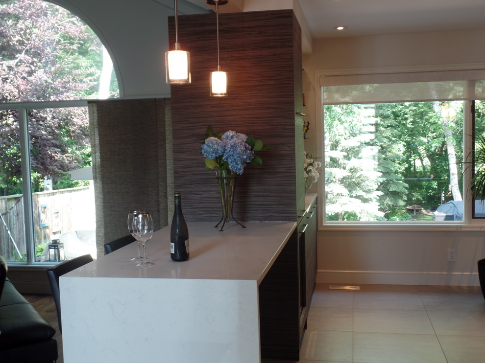 Mid-sized transitional l-shaped porcelain tile and beige floor enclosed kitchen photo with an undermount sink, flat-panel cabinets, medium tone wood cabinets, quartz countertops, white backsplash, subway tile backsplash, paneled appliances and an island