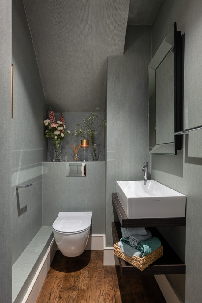 На фото: маленький туалет в современном стиле с подвесной тумбой, потолком с обоями и обоями на стенах для на участке и в саду
