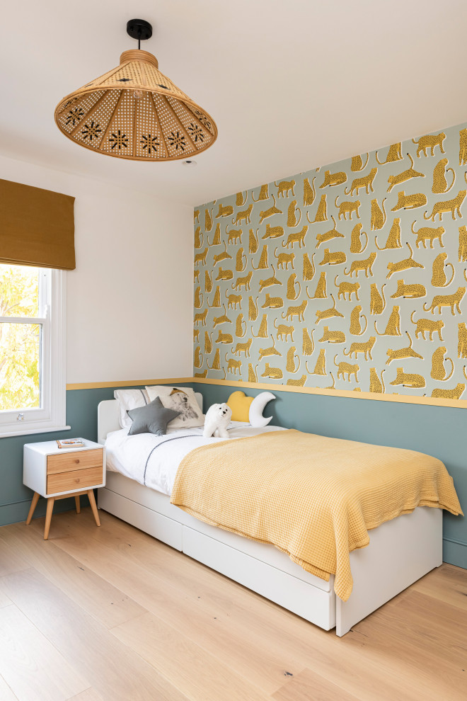 Diseño de dormitorio infantil de 1 a 3 años contemporáneo de tamaño medio con paredes azules, suelo de madera clara, suelo beige y papel pintado