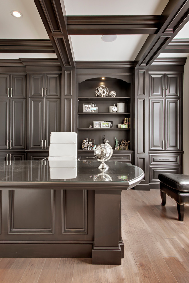 Example of a transitional home office design in Calgary