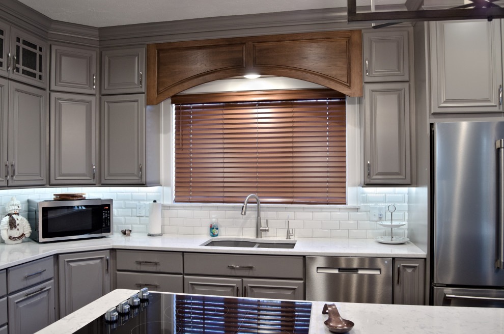 Eat-in kitchen - u-shaped brown floor eat-in kitchen idea with a double-bowl sink, raised-panel cabinets, gray cabinets, marble countertops, white backsplash, stainless steel appliances, an island and white countertops