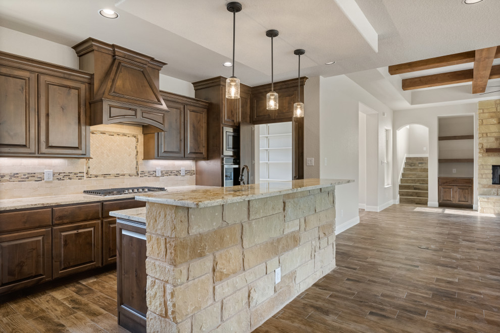 Example of a mountain style medium tone wood floor kitchen design in Austin with shaker cabinets, dark wood cabinets, granite countertops, mosaic tile backsplash, stainless steel appliances and an island