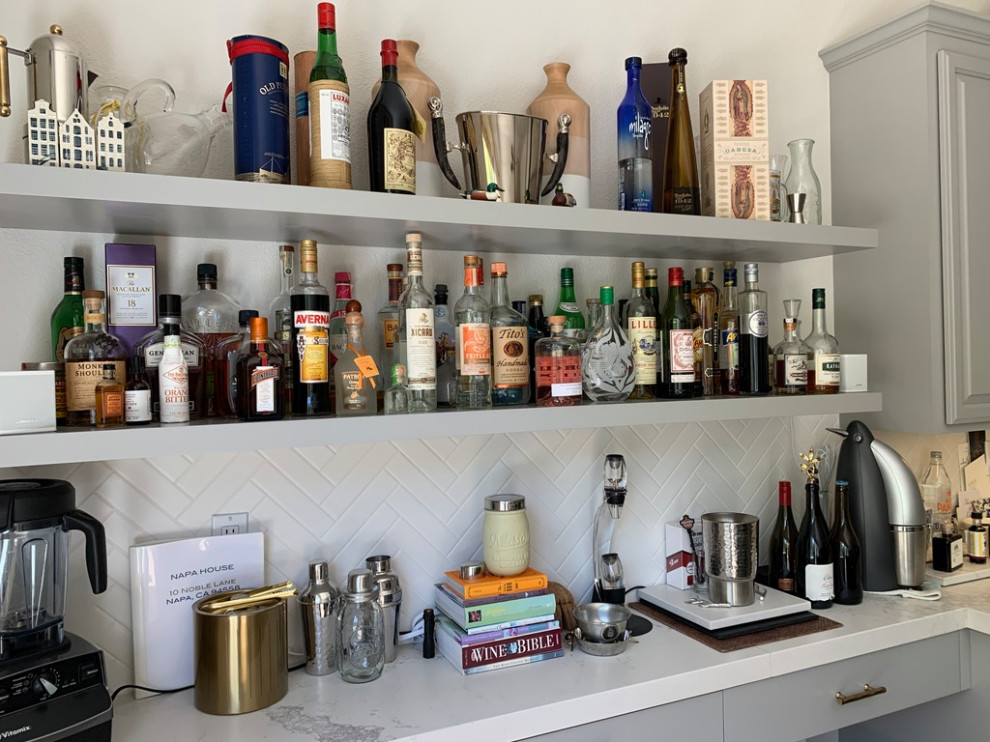 This is an example of a mid-sized transitional single-wall home bar in San Francisco with shaker cabinets, grey cabinets, quartz benchtops, porcelain splashback, medium hardwood floors, brown floor and white benchtop.
