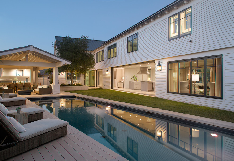 Photo of a transitional backyard rectangular pool in San Diego with decking and a pool house.