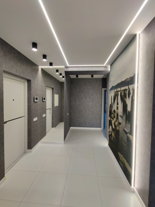 This is an example of a mid-sized contemporary hallway in Moscow with white walls, ceramic floors, white floor and wallpaper.