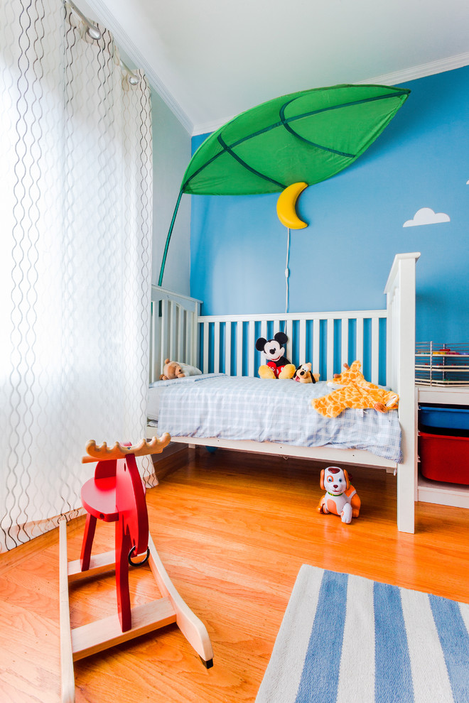 This is an example of a transitional gender-neutral nursery in San Francisco with medium hardwood floors.