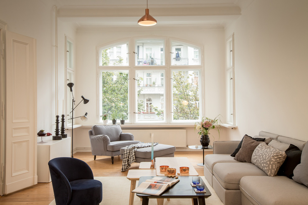 Photo of a mid-sized transitional enclosed living room in Berlin with white walls and light hardwood floors.