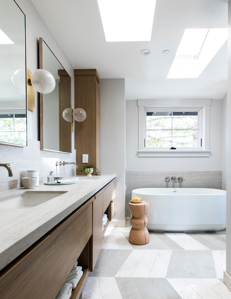 Contemporary bathroom in San Francisco with flat-panel cabinets, medium wood cabinets, a freestanding tub, white walls, an undermount sink, grey floor and grey benchtops.