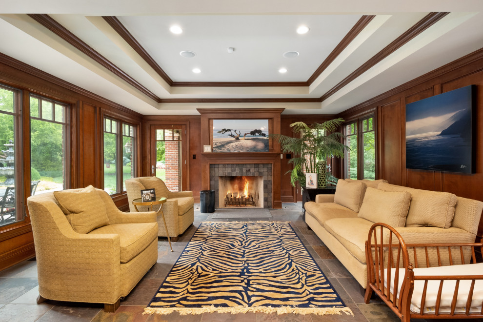 Design ideas for a large traditional enclosed living room in St Louis with brown walls, slate floors, a standard fireplace, a stone fireplace surround, no tv, multi-coloured floor, recessed and wood walls.